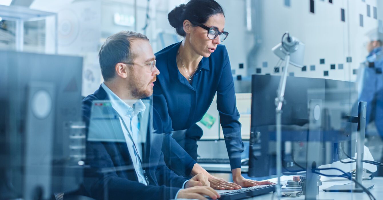 modern-electronics-factory-female-supervisor-talks-male-electrical-engineer-who-works-computer-with-cad-software-developing-pcb-microchips-semiconductors-telecommunications-equipment